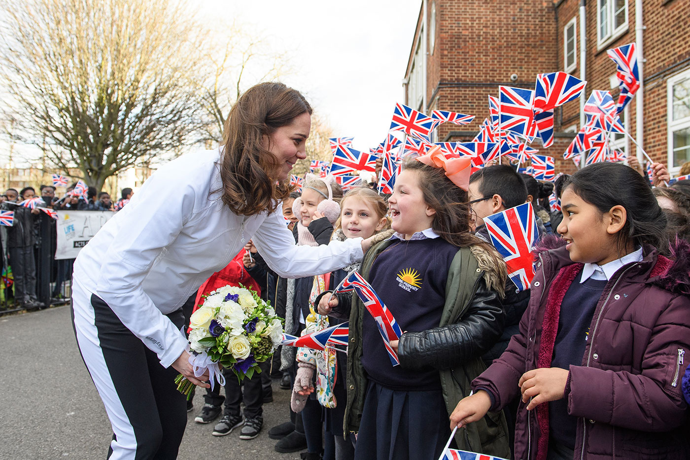 The Duchess of Cambridge greets children from Bond Primary School